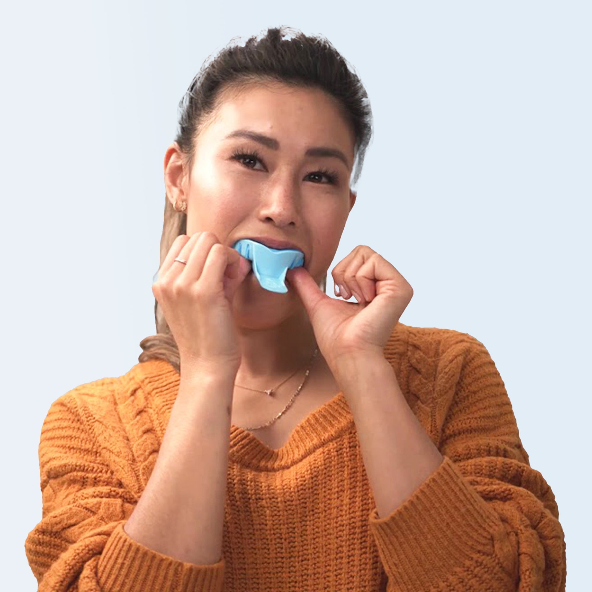 Woman taking at-home dental impressions with orange and light blue impression kitRetry