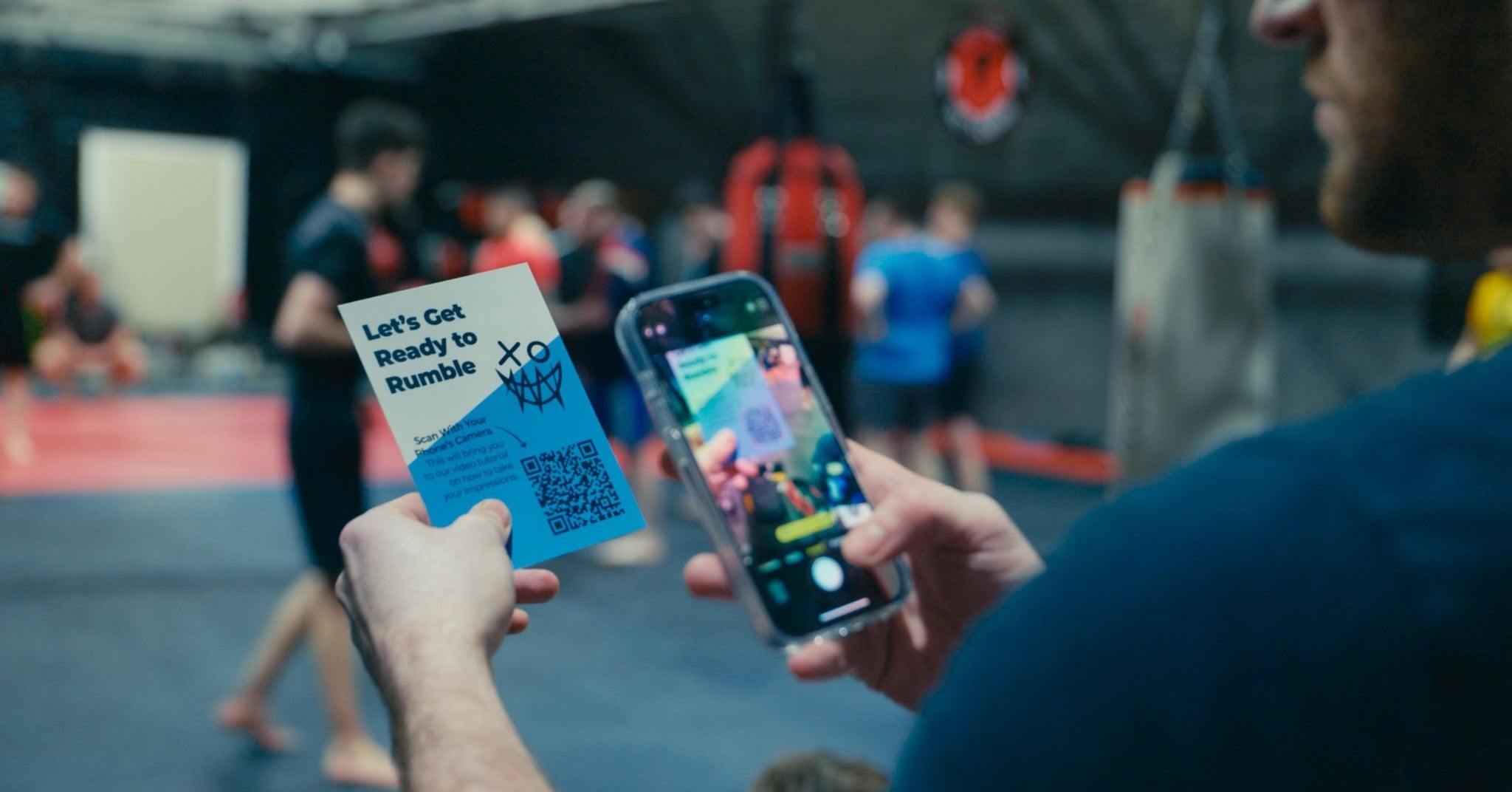 man taking photo of piranha impression QR code in gym 